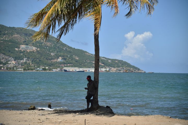 A man checks his cellphone next to the sea in Cap-Haitien, on September 6, 2017, 240 km from Port-au-Prince.