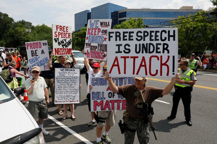 Gun rights demonstrators, including one armed with a rifle, walk through protesters aligned with the Women's March as they hold a rally against the National Rifle Association at NRA headquarters in Fairfax, Virginia, 14 July.