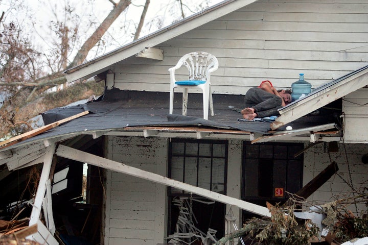 A man sleeps on the roof of his porch in Biloxi, Mississippi, on Sept. 1, 2005, after Hurricane Katrina destroyed his home.