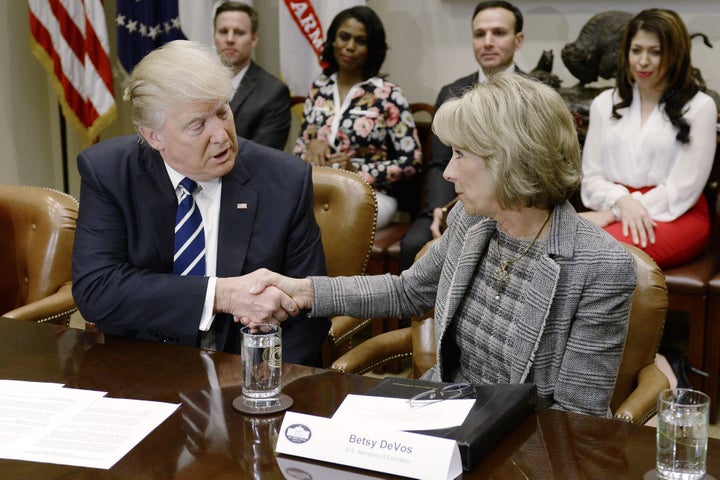 President Donald Trump shakes hands with Betsy DeVos during a parent-teacher conference listening session inside the Roosevelt Room of the White House on Tuesday, Feb. 14, 2017. 