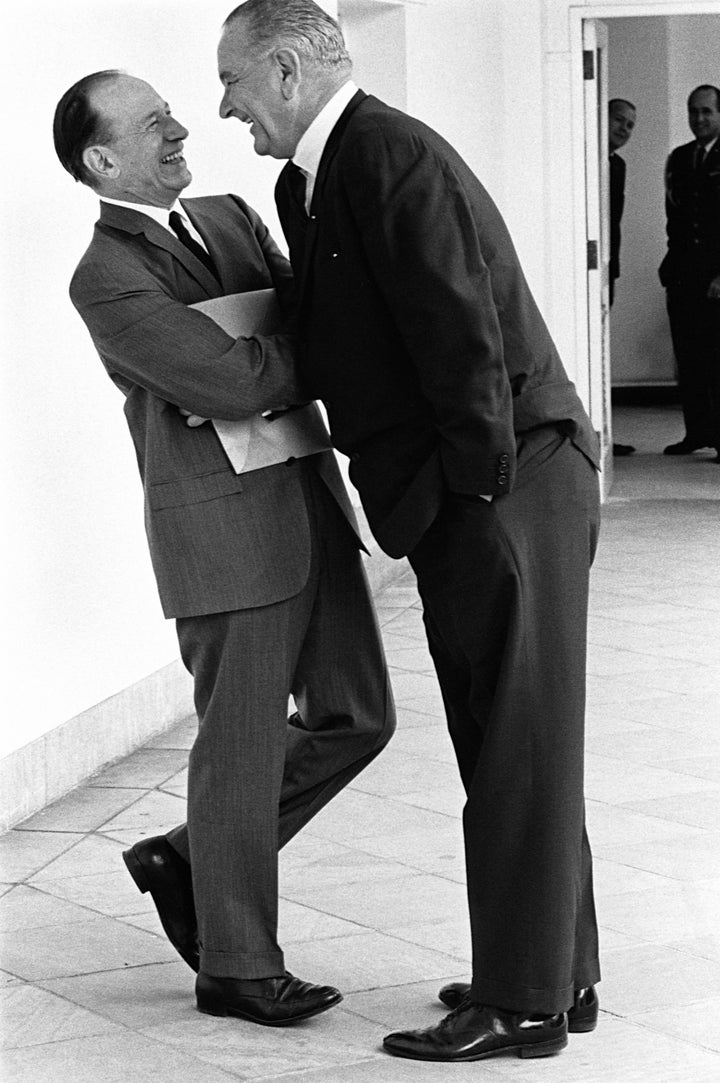 President Lyndon B. Johnson leans over a political colleague in mock intimidation to parody how he gets his way in Washington.