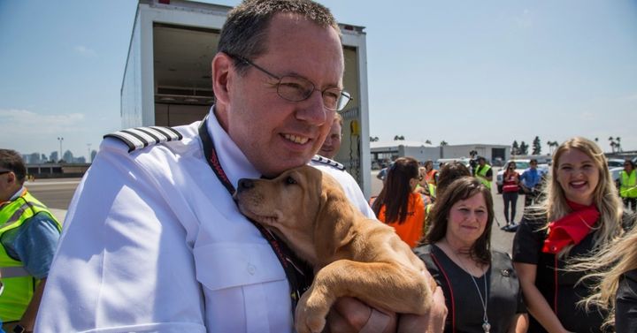 A pilot cradles a puppy during a rescue mission taking Harvey-hit animals to San Diego.