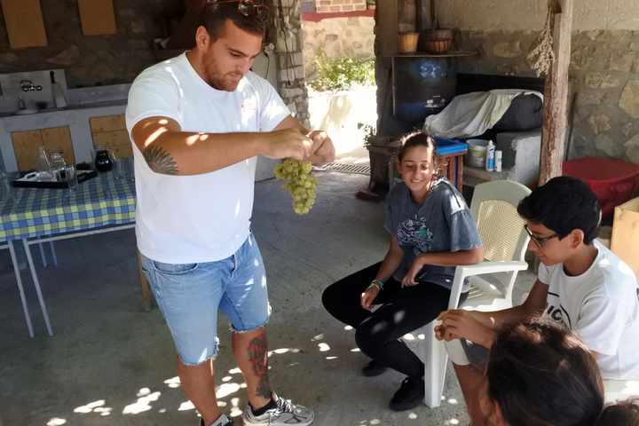 <p>Giannis offering the children the sweetest grapes I’ve ever tasted. </p>