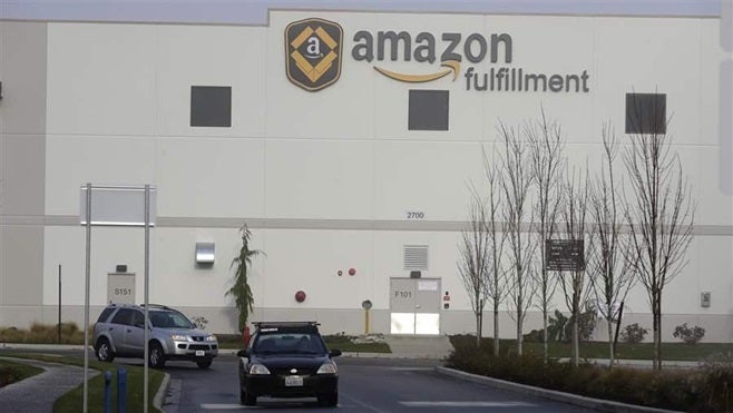 Cars drive away from an Amazon fulfillment center in DuPont, Washington. Twenty-four states are conducting an amnesty program for third-party sellers that contract with Amazon to distribute their goods but have failed to pay sales taxes.