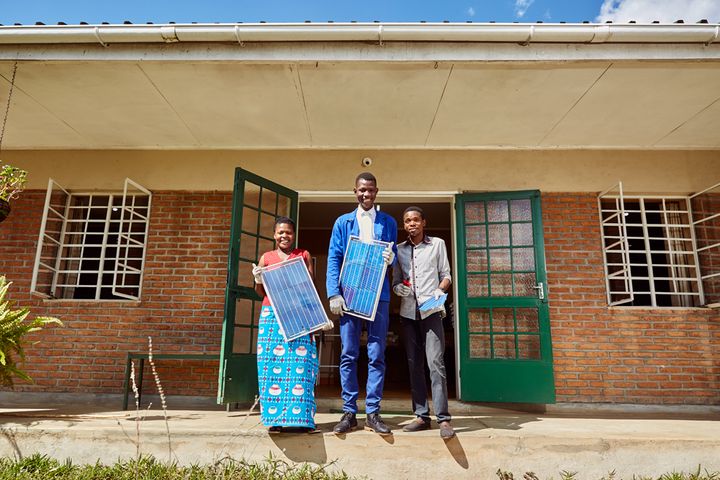 From left to right: Jennifer, Thomas, and Alex, students at Green Malata, an entrepreneurial village, pose with some of their solar panels, Luchenza, southern Malawi, 2017. 