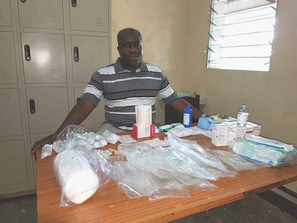 Dr. Wilfrid Mutombo sits with all the items needed to treat a single sleeping sickness patient.