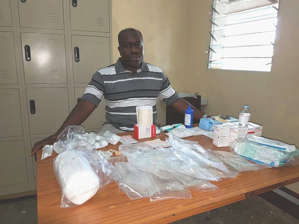 Dr. Wilfrid Mutombo sits with all the items needed to treat a single sleeping sickness patient.