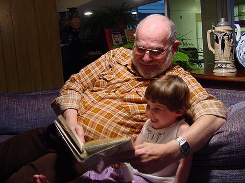 Grandfather reading with grandchild