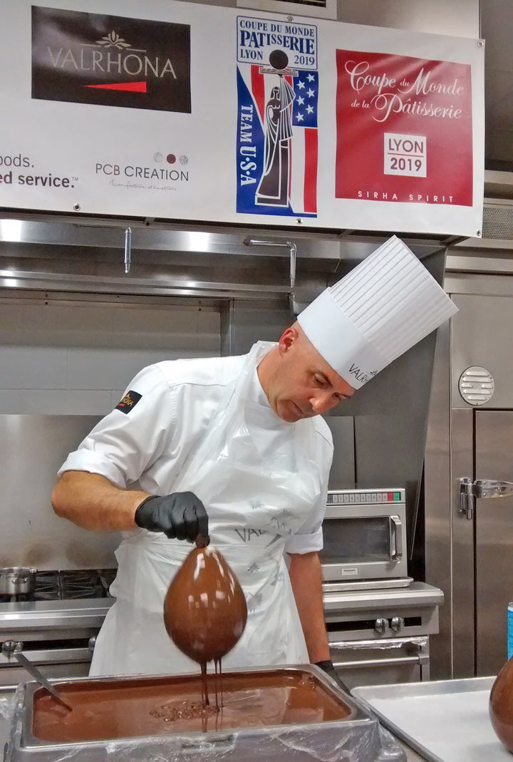 Olivier Saintemarie dips balloons in tempered chocolate to create the hourglass for his chocolate showpiece 