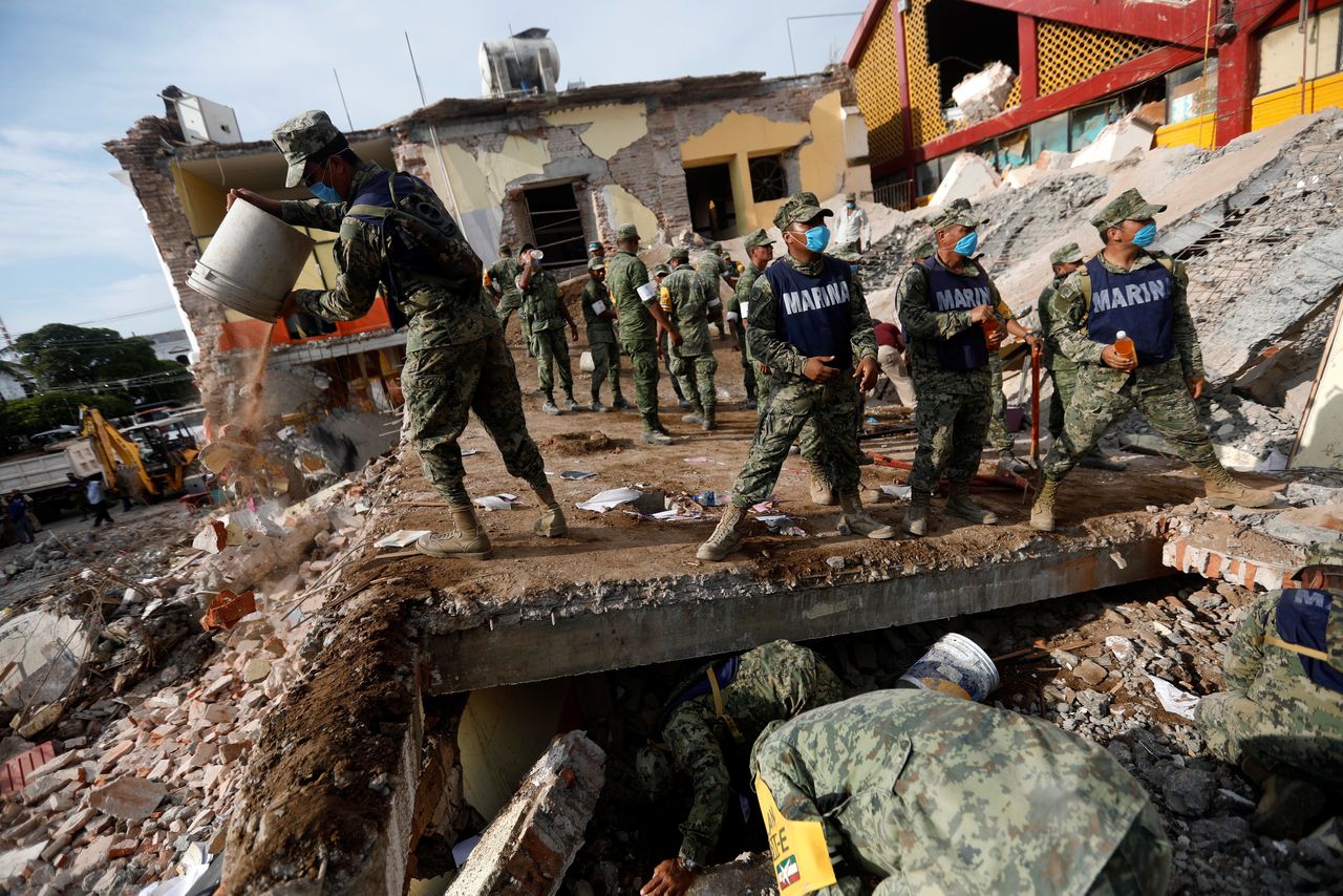 Soldiers remove the debris of a house destroyed in the earthquake 