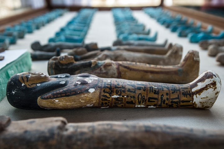 A picture taken on September 9, 2017 shows small funerary statues carved in wood, clay and limestone recovered at the site of a newly-uncovered ancient tomb for a goldsmith dedicated to the ancient Egyptian god Amun.