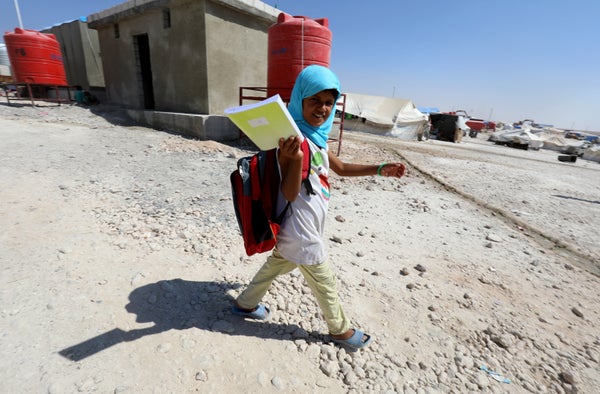 A displaced child from the Islamic State group's Syrian stronghold of Raqa walks to attend the first day of the new school ye