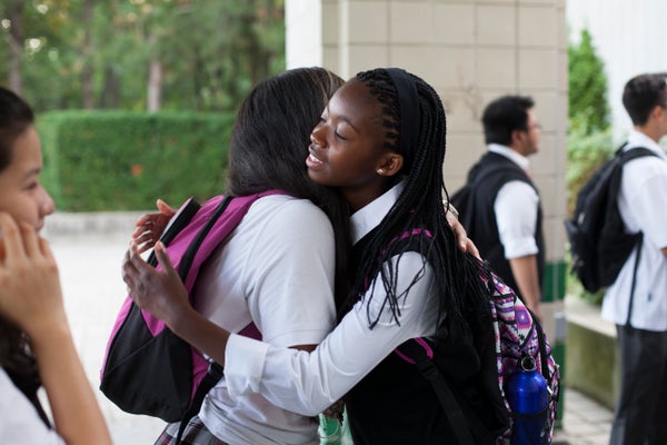 Caroline Mogomela hugs Yesenia Villada on her first day of school at St. Patrick Secondary School in Toronto.