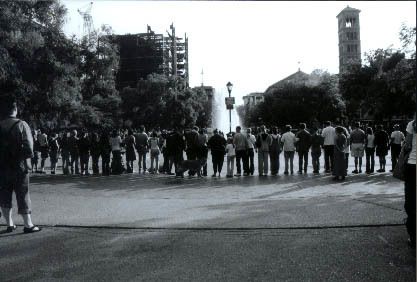 Hundreds of people spontaneously form a huge circle holding hands in the center, at the base of where the Twin Towers were viewed in Washington Square Park.
