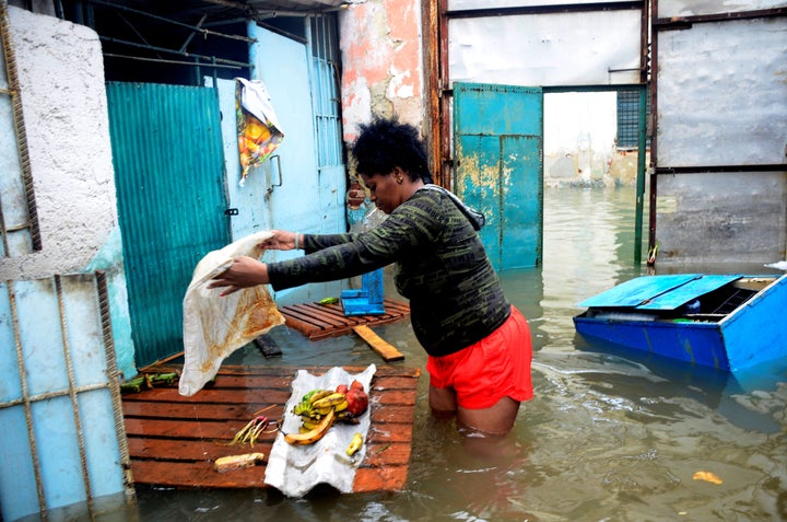 A woman tries to rescue some food from her flooded house in downtown Havana, on September 10, 2017. 