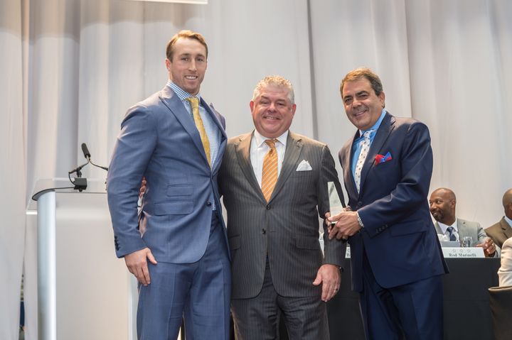 Linebacker Sean Lee (left) is awarded the Defensive MVP Award by Rusty Smith, GM of Neiman Marcus Willow Bend (center) and Steven Behar, co-owner of Ike Behar (right)