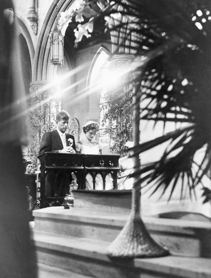 The couple kneel during the ceremony.