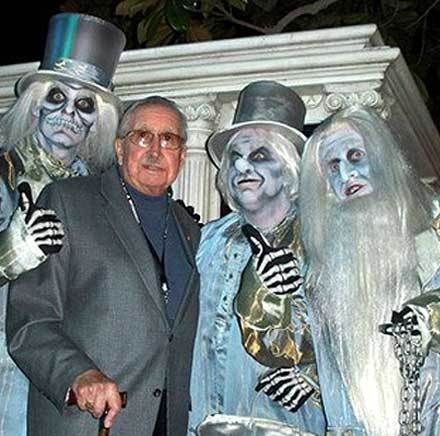 X Atencio and a trio of hitchhiking ghosts posed for a photo at an anniversary event for Disneyland’s Haunted Mansion.