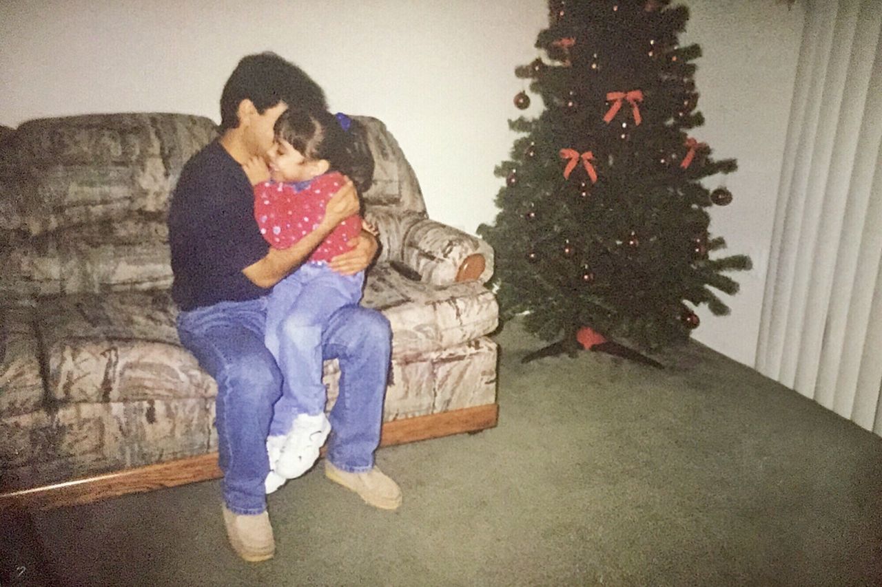 Karla Perez, as a child, with her dad at Christmastime.