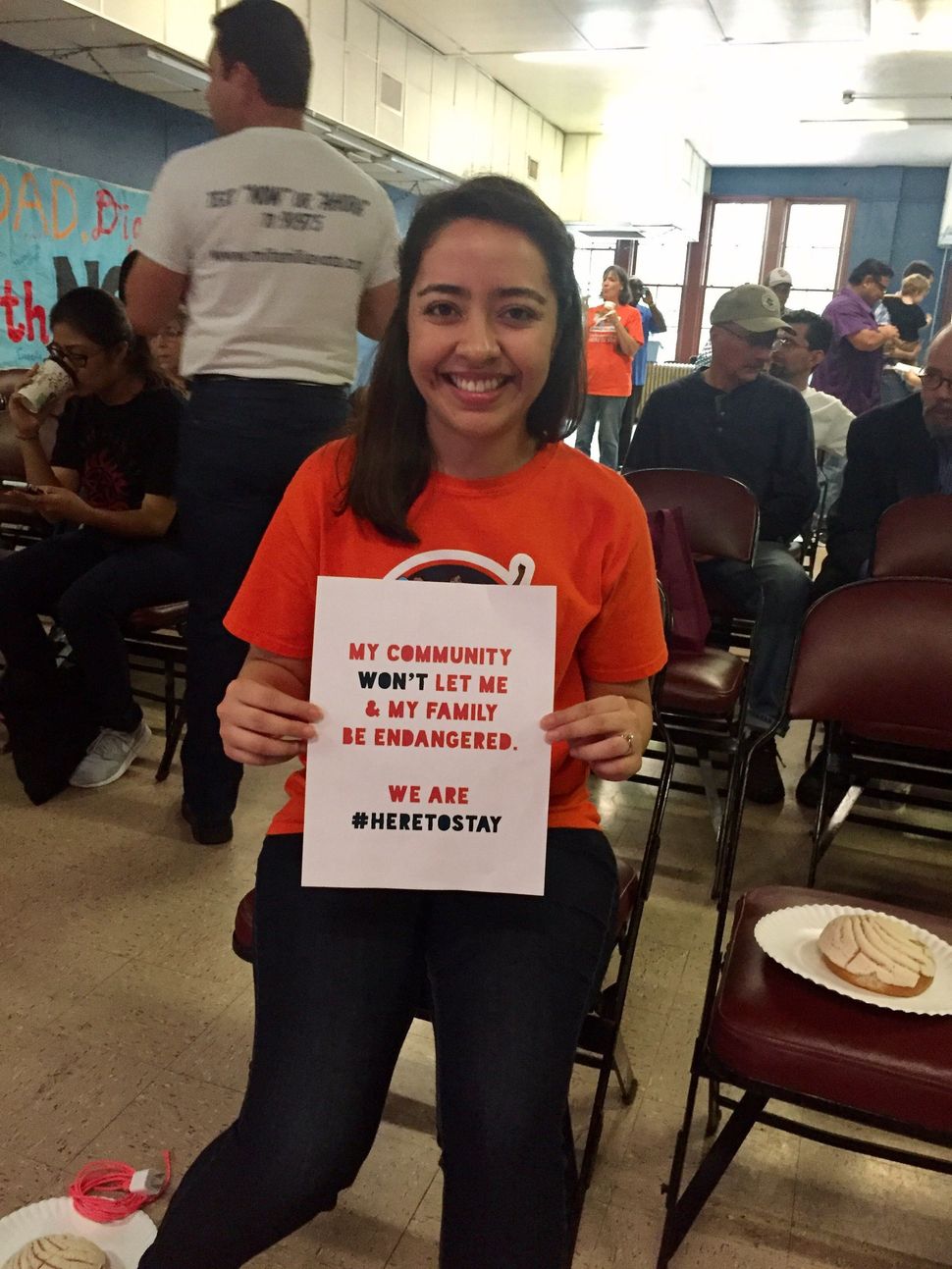 Karla Perez poses with a #HereToStay sign. 