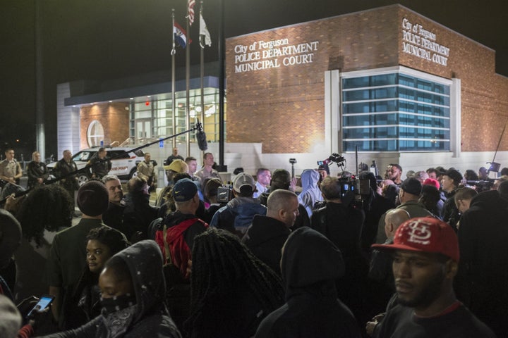 Protestors gather in front of the Ferguson Police Department after the Justice Department released their report exposing corruption in the police department and court system of Ferguson on March 12, 2015.