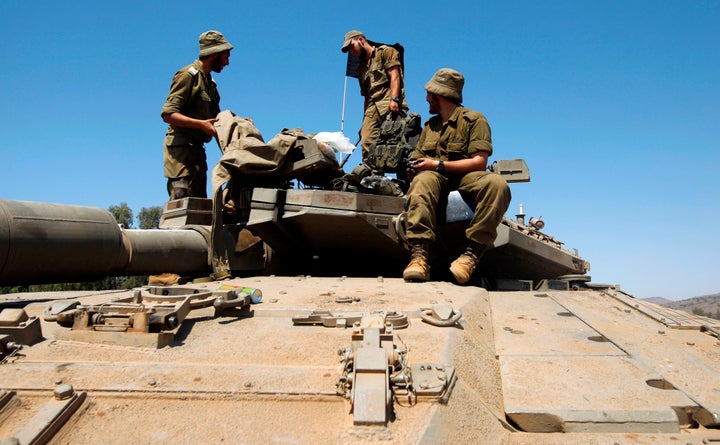 A picture taken on September 13, 2017 shows Israeli soldiers standing on the top of a Merkava tank during the last day of a military exercise in the northern part of the Israeli-annexed Golan Heights. 