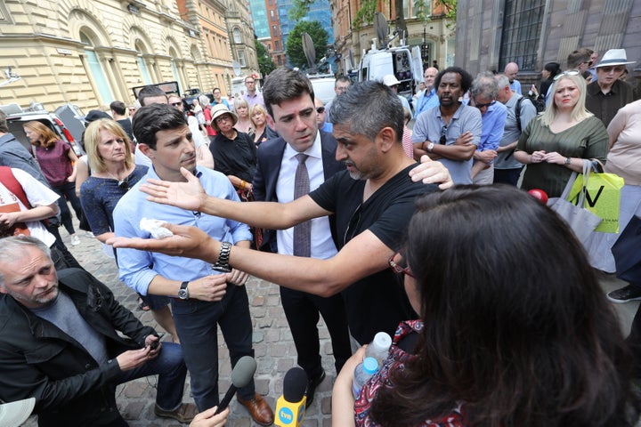 <strong>Burnham comforts Hashim Norat as he is interviewed in St Ann's Square, Manchester, where a minute's silence was held to remember the victims of the terror attack</strong>
