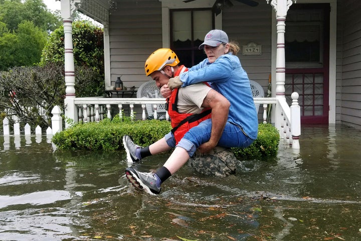 A Texas National Guardsman carries a resident from her flooded home following Hurricane Harvey in Houston, Aug. 27, 2017.
