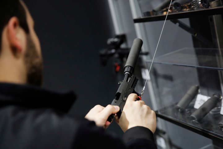 A visitor pulls the slide of a pistol with a silencer at a National Rifle Association outdoor sports trade show on Feb. 10, 2017, in Harrisburg, Pennsylvania.