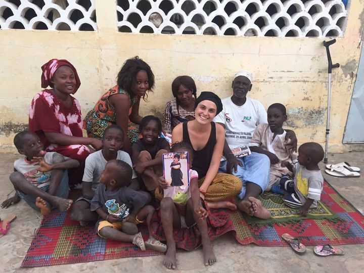 Maria sitting with her extended host family during her gap year in Senegal.