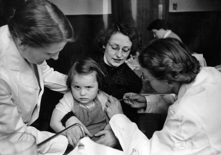 A rather reluctant-looking girl receives the polio vaccine in Britain in 1956.