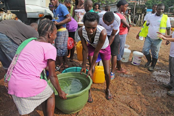 Members of the Kaningo community gather clean water trucked in by Concern. 