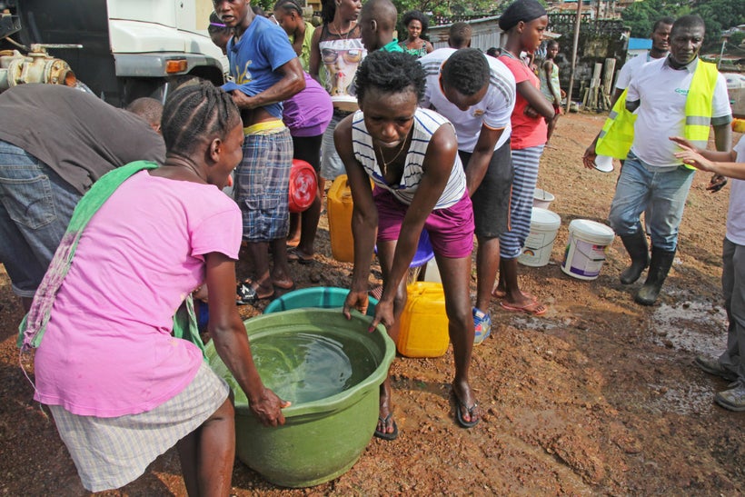 Members of the Kaningo community gather clean water trucked in by Concern.
