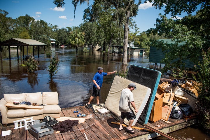 Marc St. Peter, left, and Chris Wisor lend a hand cleaning up as floodwaters from Hurricane Irma recede Wednesday in Middleburg, Florida.