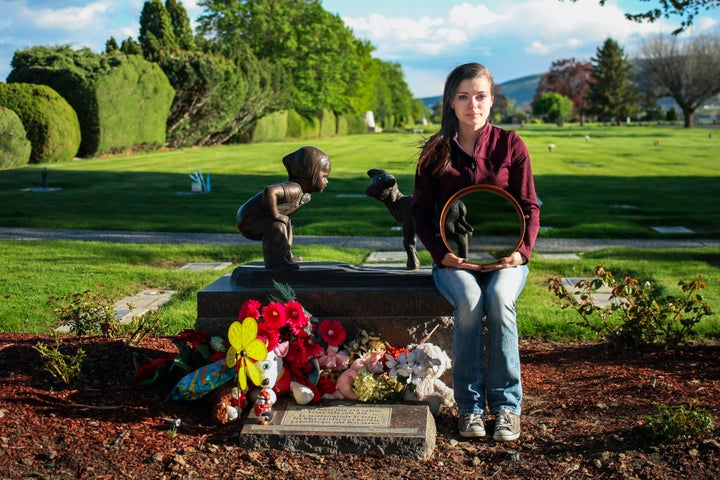 Butterworth photographs parents who’ve faced child loss holding mirrors in front of their bodies.