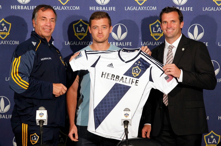 Los Angeles Galaxy head coach Bruce Arena (L) and team president Chris Klein (R) introduce the signing of midfielder Robbie Rogers at a news conference in Carson, California, on May 25, 2013. 