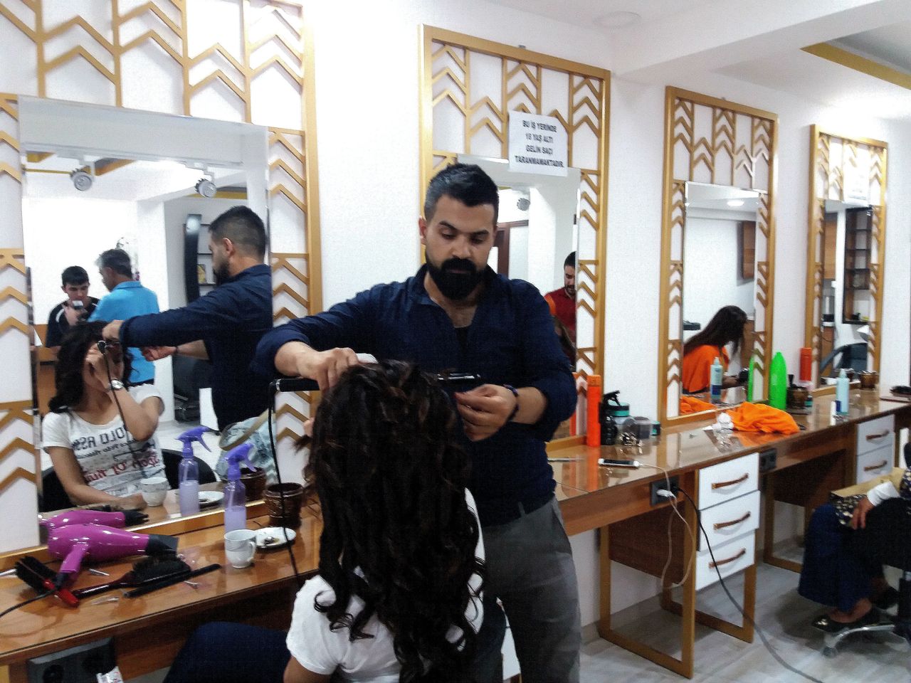 At Ali İncili's hair salon, a sign on the mirror reads, "In our premises, we do not offer hairdressing services to brides under 18."