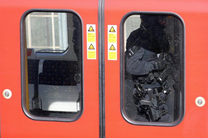 Armed police officers walk through a carriage on the train