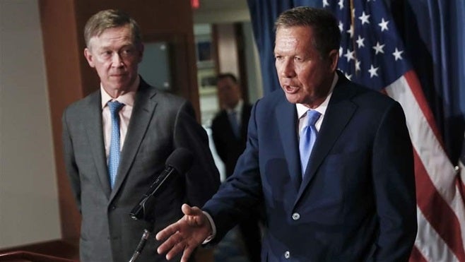 Govs. John Hickenlooper of Colorado (left) and John Kasich of Ohio discuss health care reforms in Washington in June. They ar