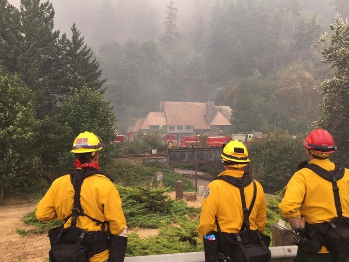 Firefighters keep an eye on the historic Multnomah Falls Lodge, trying to save it from the Eagle Creek Fire.