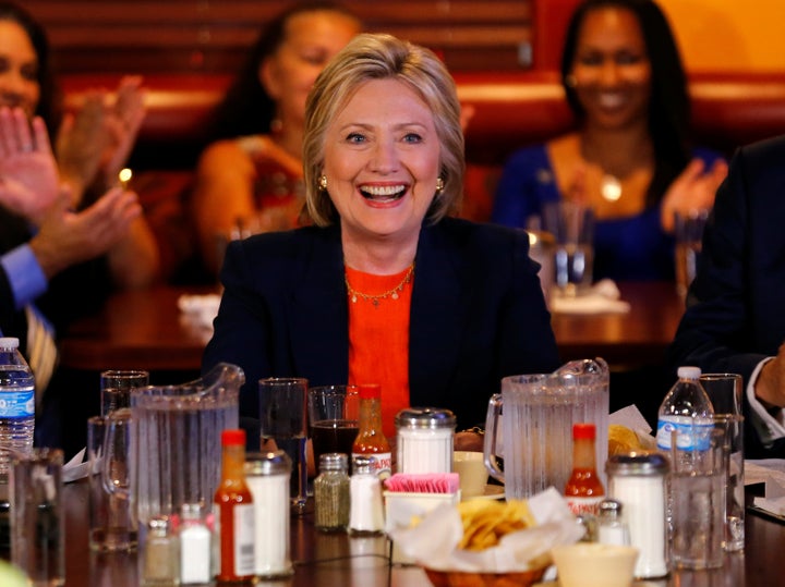 Clinton smiles amid hot sauce bottles while making a campaign stop at a restaurant in Perris, California on June 2, 2016