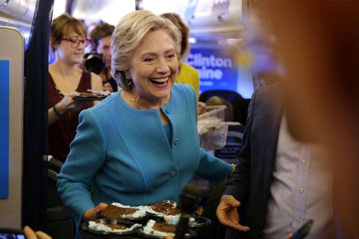 Clinton brings birthday cake to members of the media inside her campaign plane en route to New York on October 26,