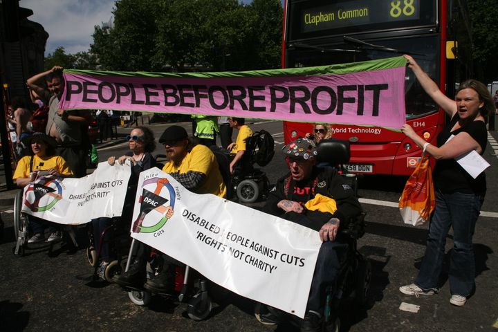 The group, Disabled People Against Cuts, block the road outside Westminster Abbey