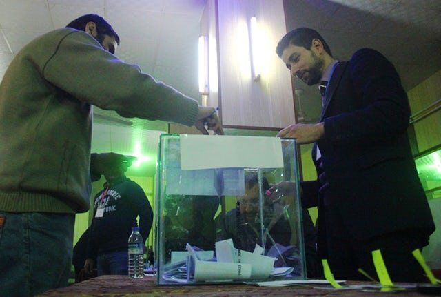 A Syrian man casts his vote in a ballot box at a polling station in the city of Idlib as the city’s first civilian council is elected, two years after it was overrun by rebels and jihadists, on January 17, 2017.