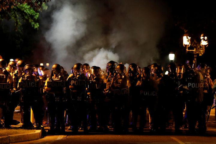 Law enforcement officials line a residential street where people protest on September 15, 2017.