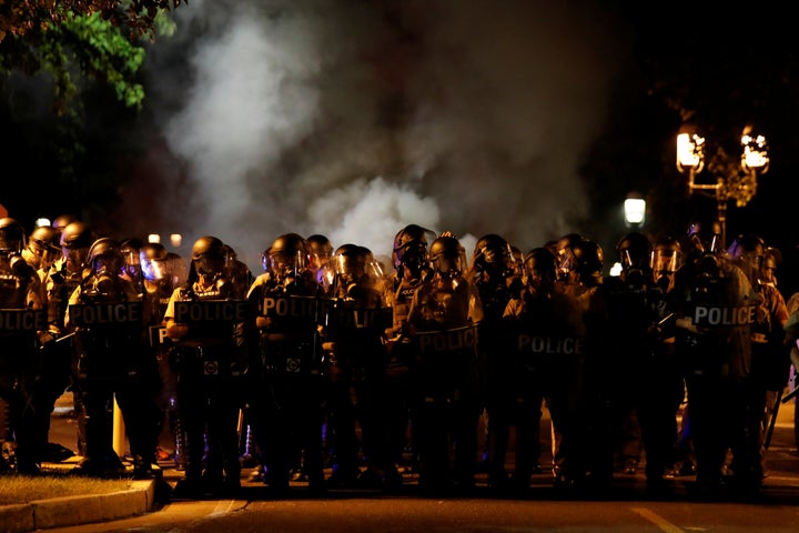 Law enforcement officials line a residential street where people protest on September 15, 2017.