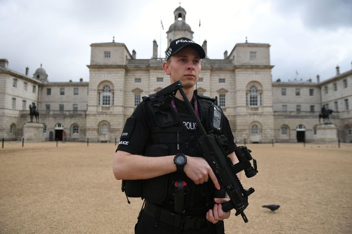 An armed police officers stands guard outside the House Guards Parade in central London on Saturday