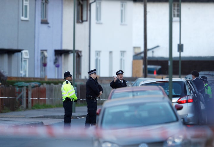 Police officers stand behind cordon tape near a property that was searched after a man was arrested in connection with an explosion on a London Underground train, in Sunbury-on-Thames, Britain, September 16, 2017.