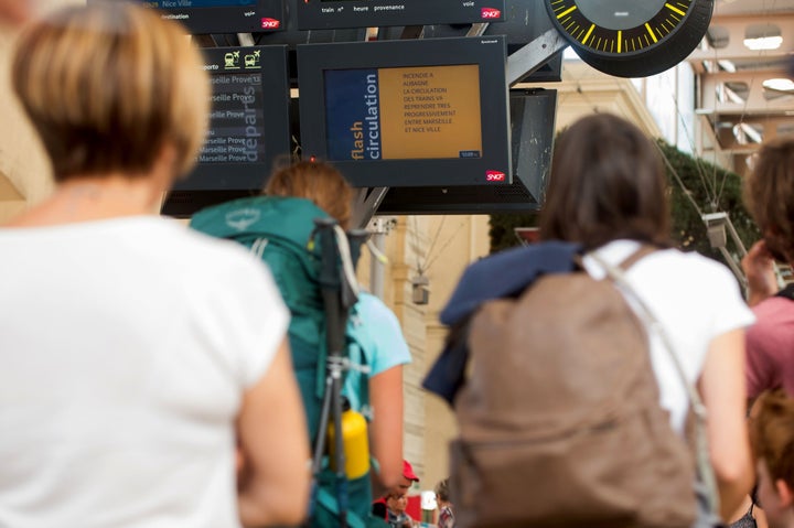 Passengers look at information monitors as they wait for their trains at The Saint-Charles Station in Marseille on August 20, 2017.