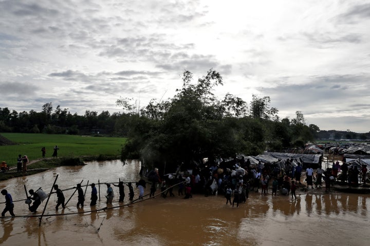 Rohingya cross a swollen river at a refugee camp in Cox's Bazar, Bangladesh, September 17, 2017. 